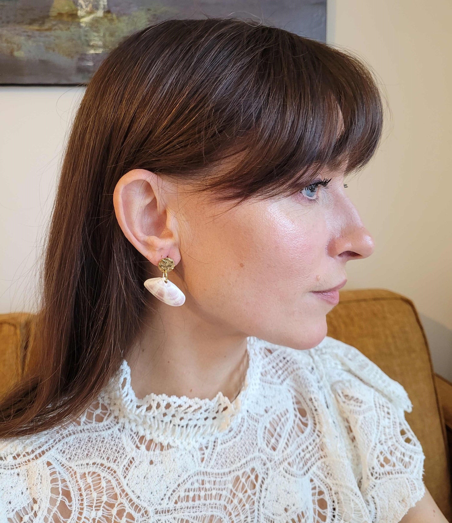 Boucles d'oreilles discrètes en coquillage fin at acier inoxydable doré, alliant élégance et simplicité marine.