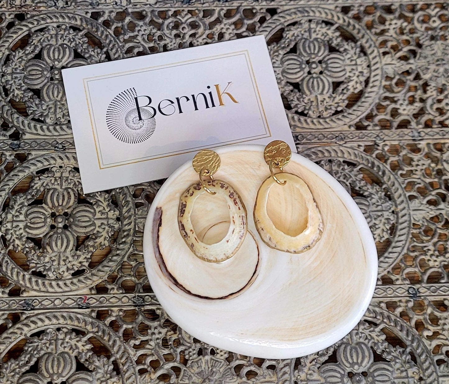 Créoles artisanales en coquillage de bernique et acier doré, légères et élégantes.