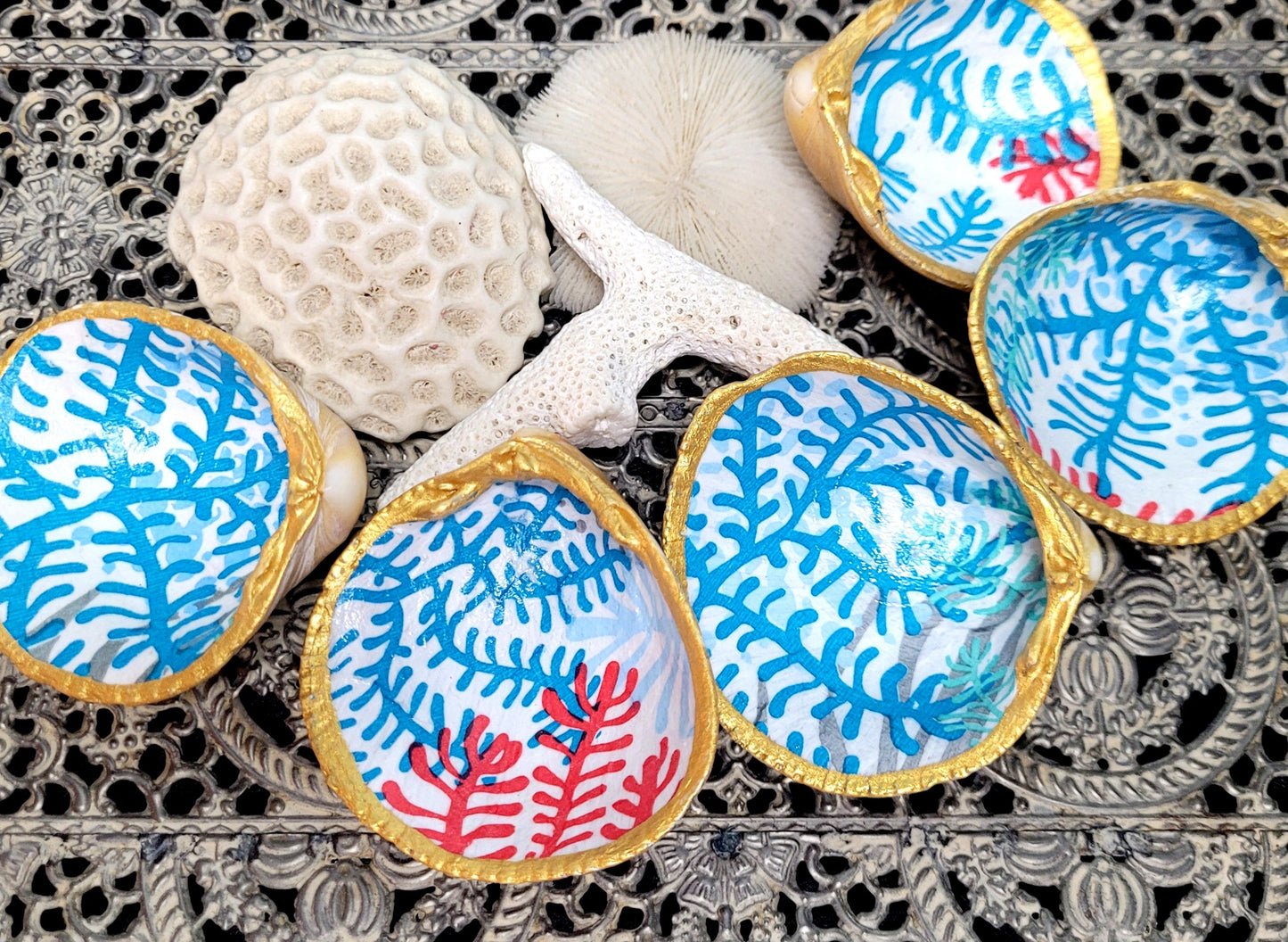 Coquillage bucarde de la collection Océane, peint à la main en bleu et rouge avec des motifs corail, idéal pour ranger vos petits objets.