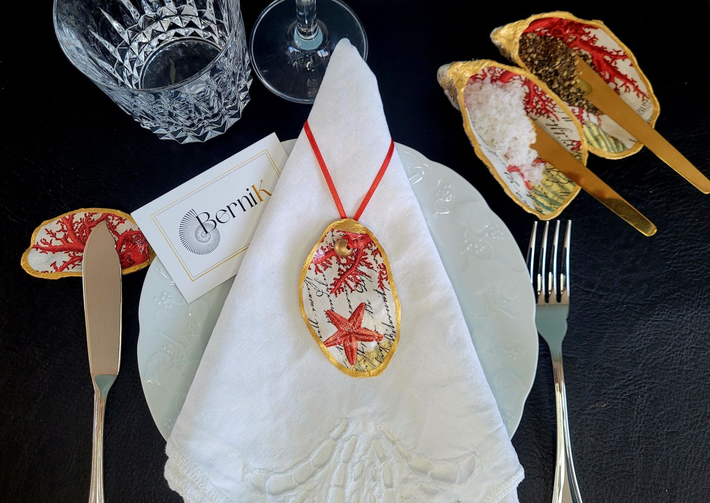 Apportez un charme marin à votre table avec ce porte-couteau en coquille d'huître, décoré de corail rouge, idéal pour des repas élégants.