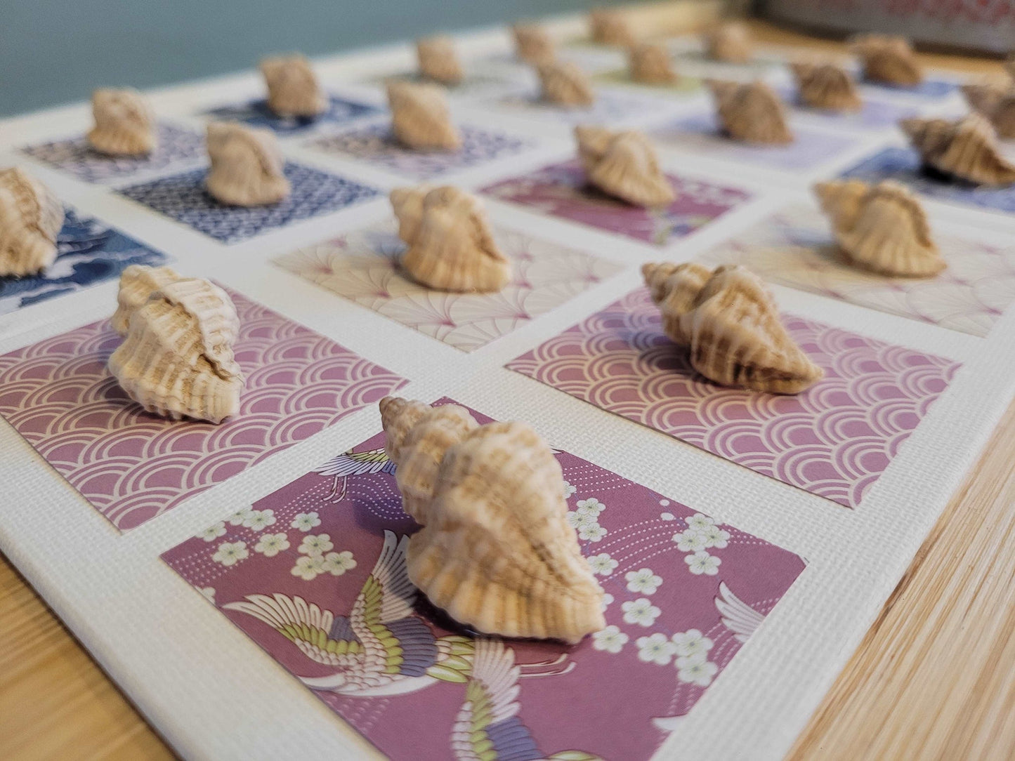 Élégance artisanale avec des tableaux en coquillages et papier origami japonais, pour une touche marine et un effet 3D unique.