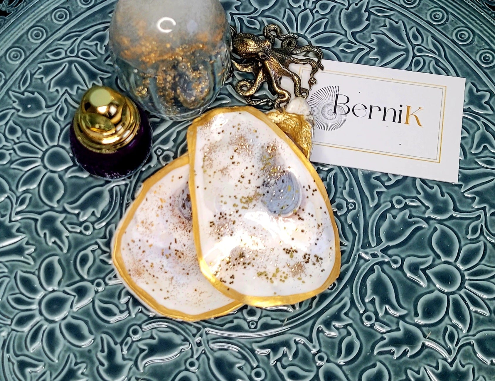 Boîte à bijoux avec coquille d'huître et paillettes dorées, créant un effet lumineux grâce à sa nacre brillante.