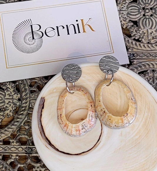 Boucles d'oreilles en acier inoxydable argenté avec coquilles de bernique, design artisanal et élégant.