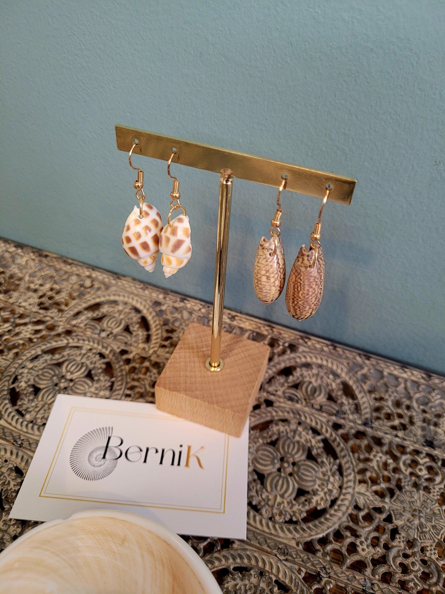 Boucles d'oreilles raffinées en coquillage brillants montées sur crochets dorés, style épuré et moderne."