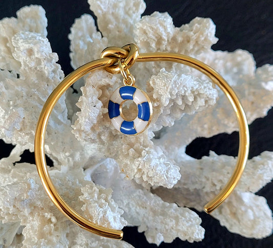 Bracelet jonc doré avec nœud marin et breloque bouée bleue et blanche, design épuré et maritime, résistant à l'eau.