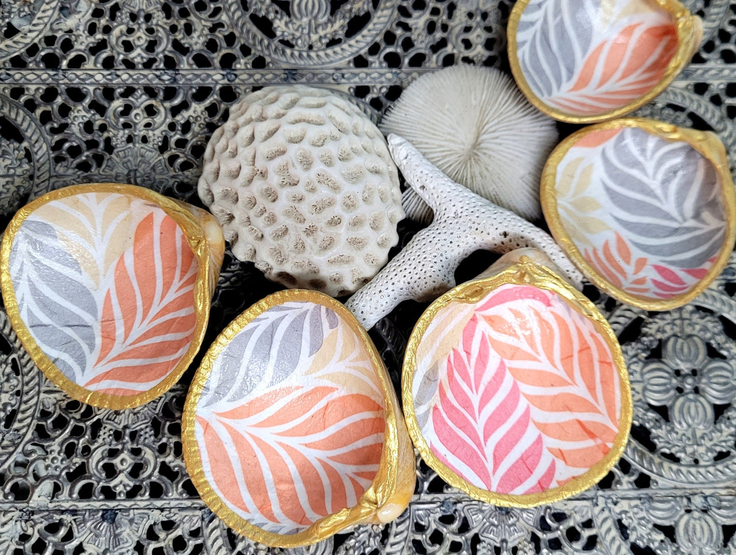 Coquillage décoré de papier de soie aux stries pastels rose, gris et orangé.