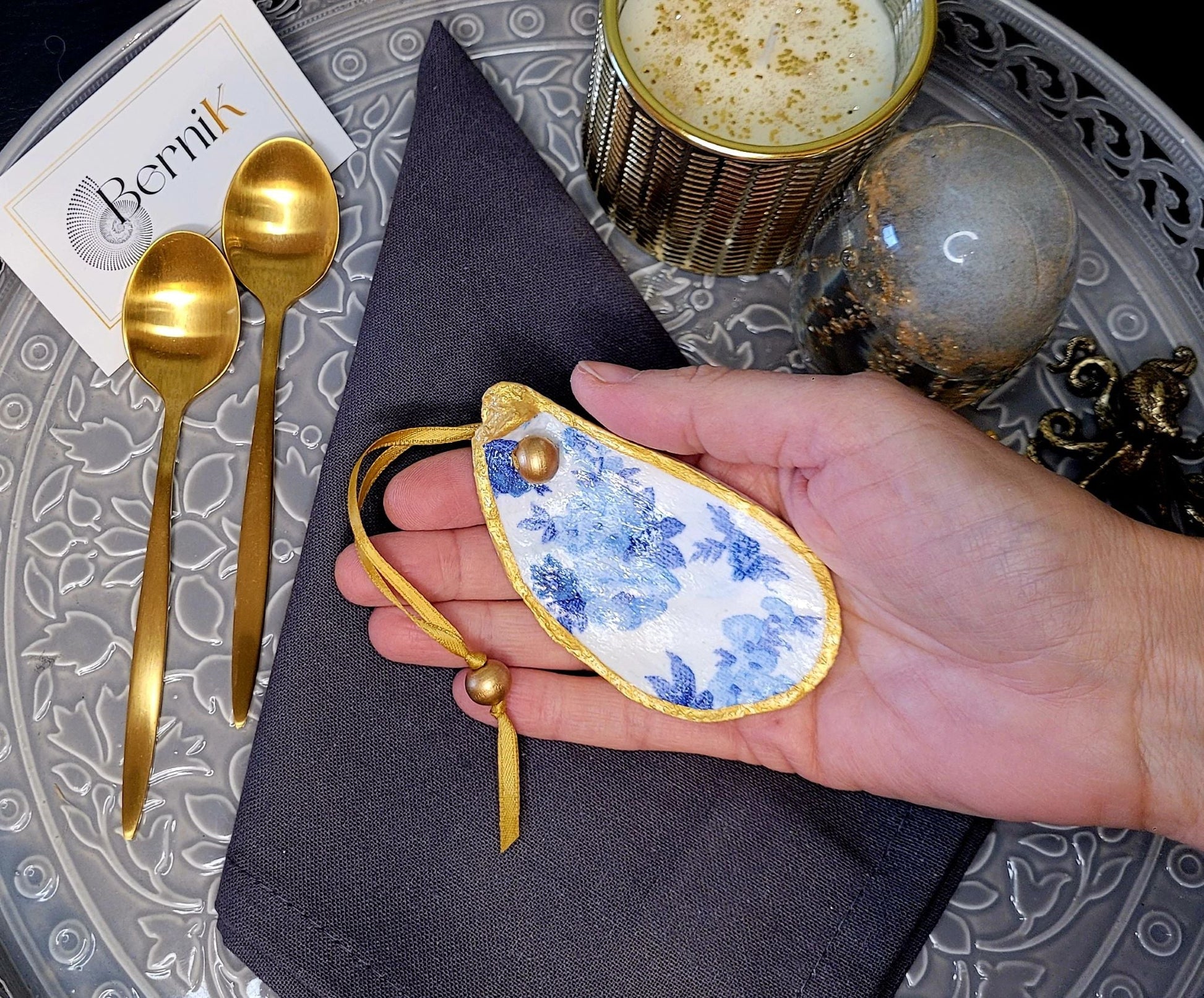 Créez une ambiance romantique avec des ronds de serviette en coquille d'huître, ornés de roses anglaises bleues, sur vos tables.