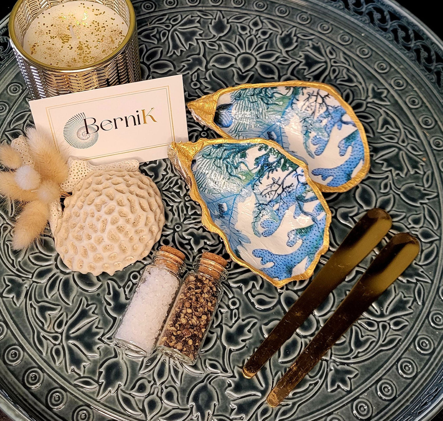 Salière et poivrière en coquille d'huître, décorées de teintes bleues et vertes, pour une table élégante et un cadeau écoresponsable.