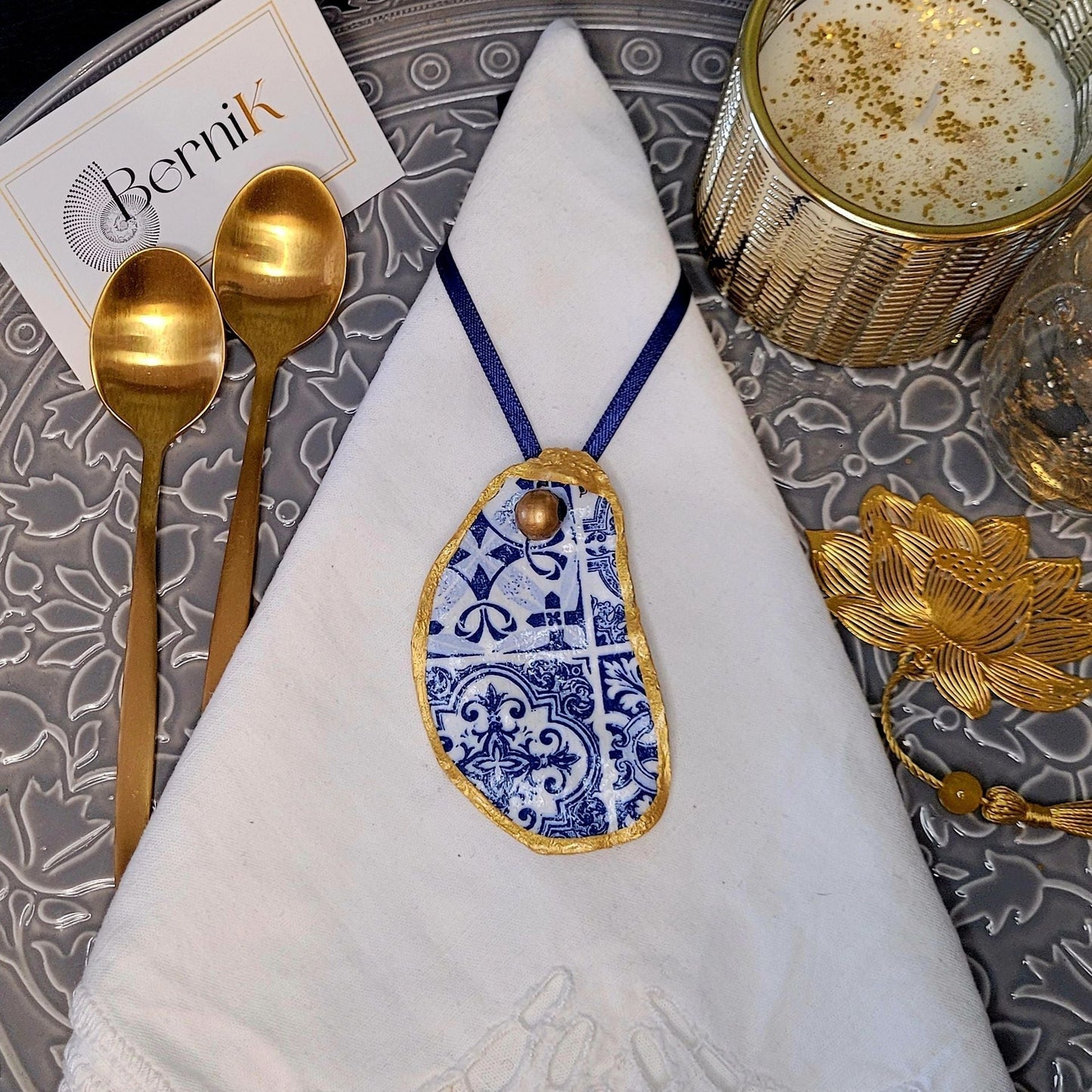 Accessoires de table artisanaux : ronds de serviette en coquille d'huître avec motifs azulejos bleus, pour un dîner élégant.