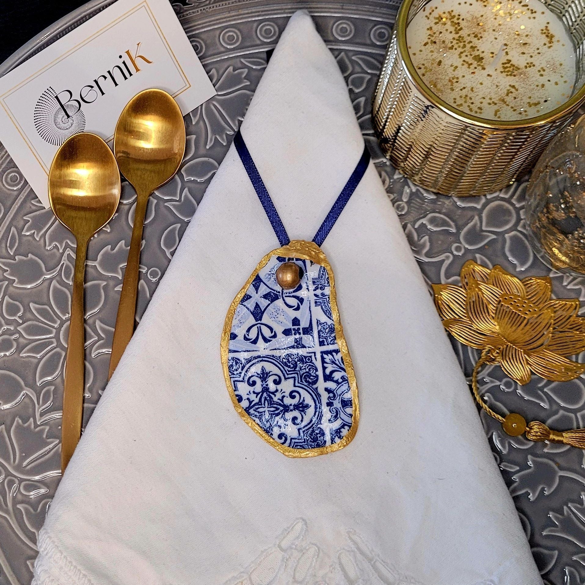 Accessoires de table artisanaux : ronds de serviette en coquille d'huître avec motifs azulejos bleus, pour un dîner élégant.