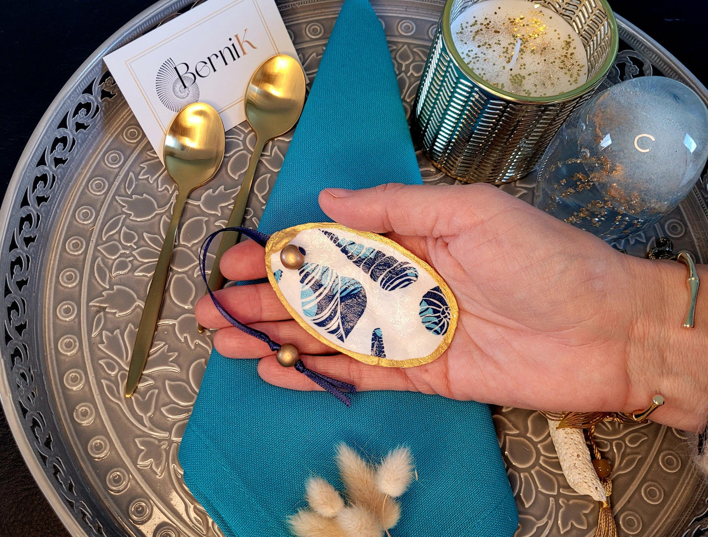 Ces ronds de serviette en coquille d'huître, décorés de coquillages bleus, apportent une touche marine raffinée à votre table.