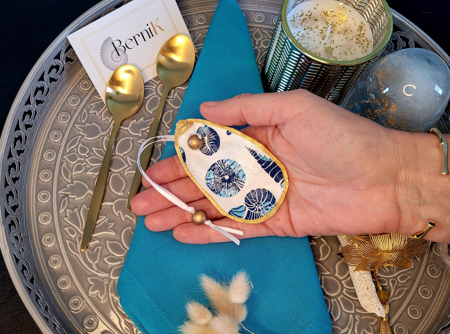 Ronds de serviette en coquille d'huître avec motifs de coquillages bleus, idéals pour une décoration marine élégante.