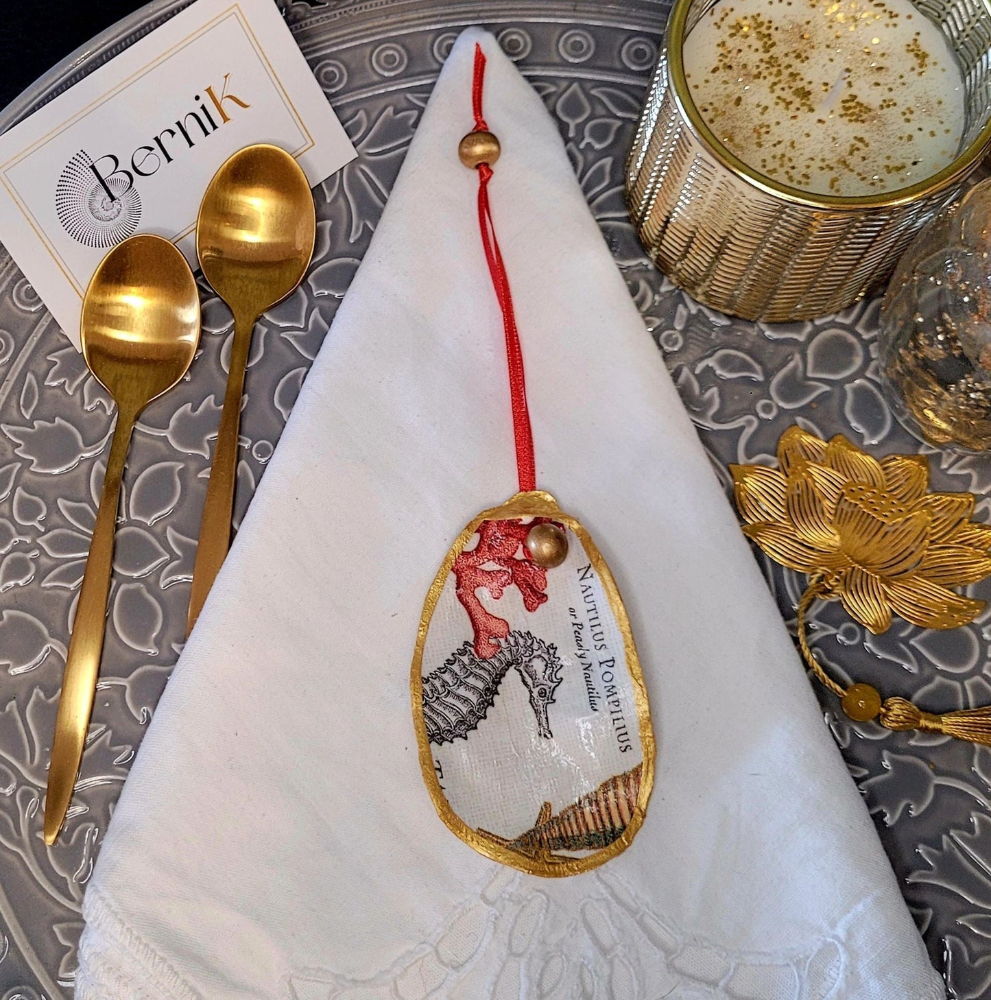 Accessoires de table artisanaux : ronds de serviette en coquille d'huître avec corail rouge et hippocampes, idéal pour repas d'été.