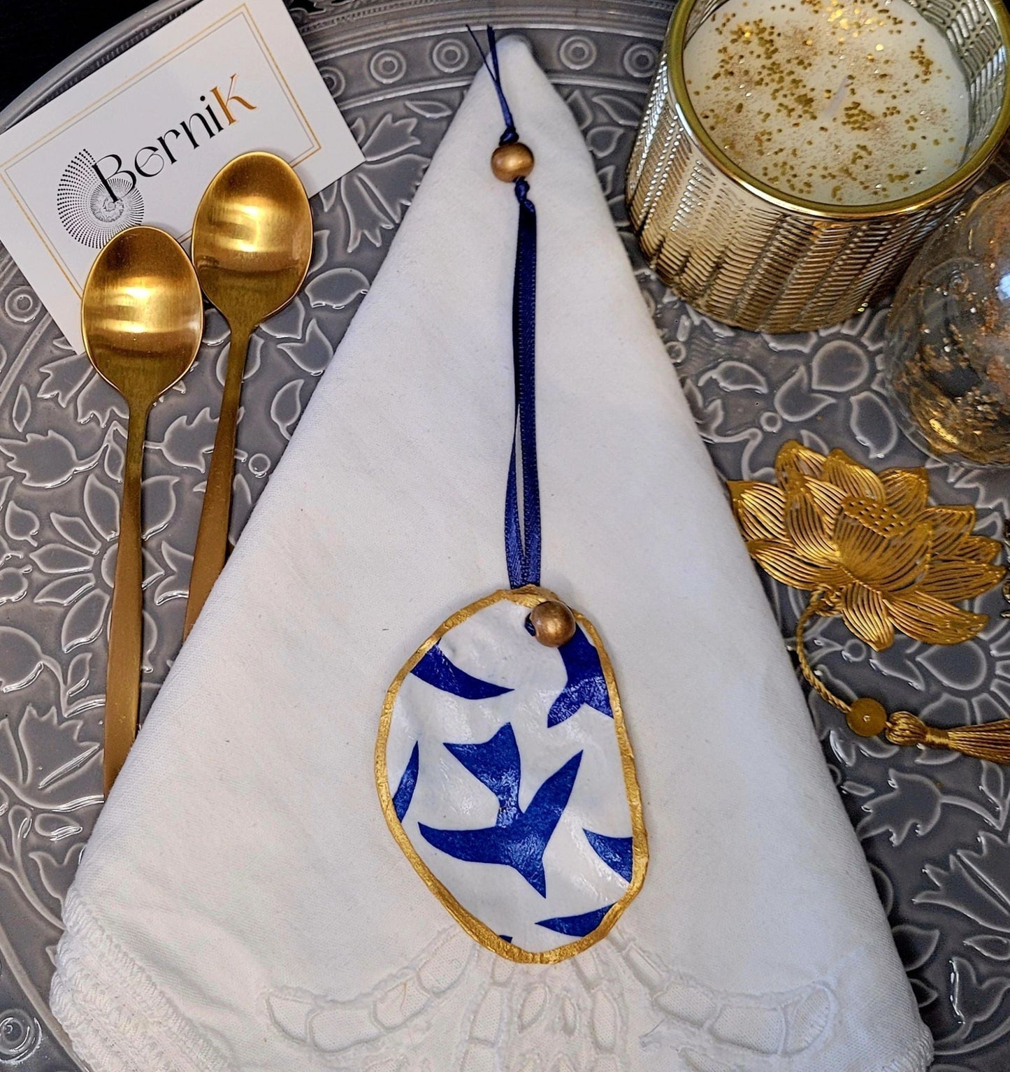 Décoration de table marine avec coquille naturelle et motifs oiseaux bleus.