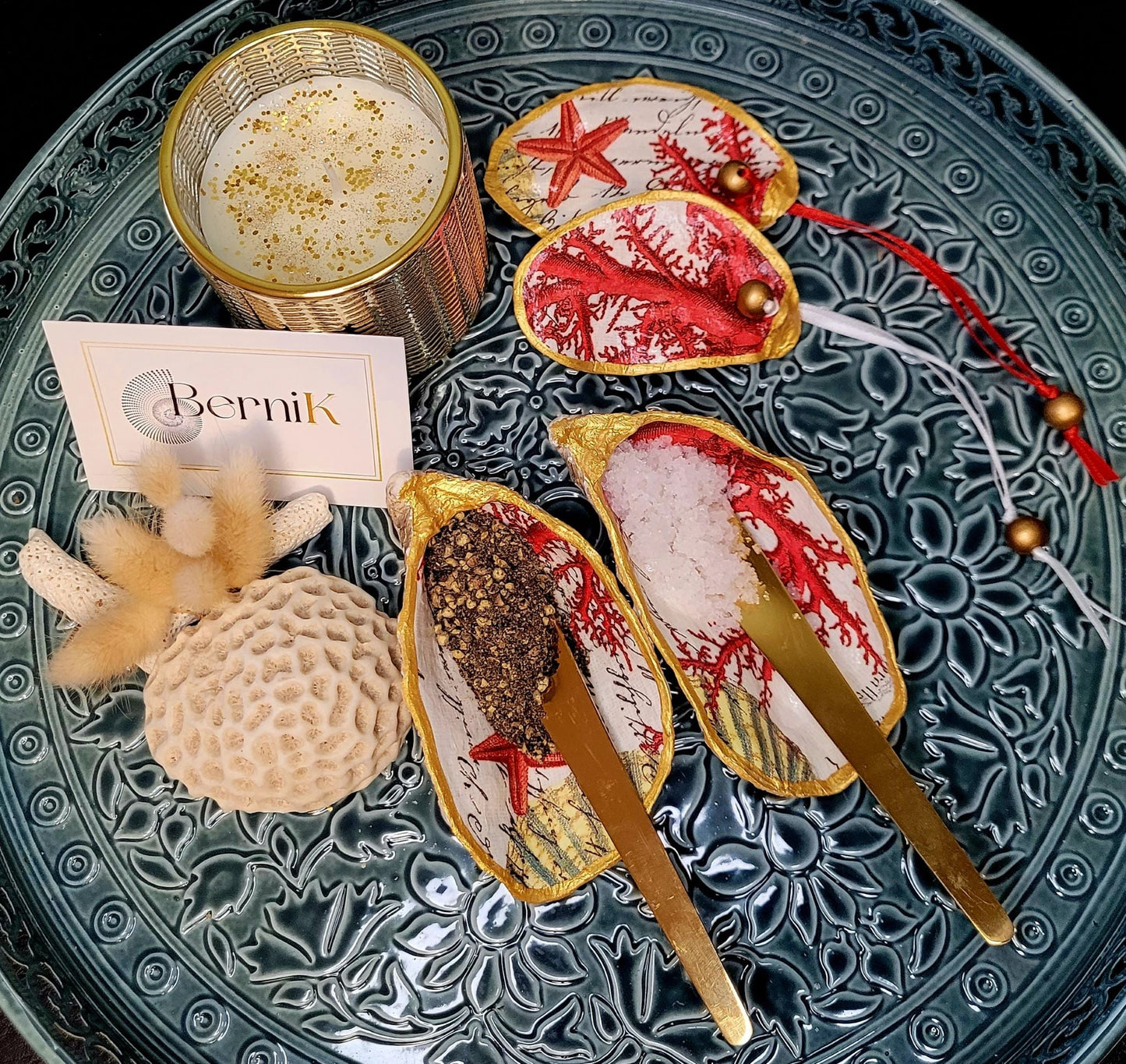 Offrez une touche de raffinement avec cette salière et poivrière en coquille d'huître décorées de corail rouge. Artisanat français unique.