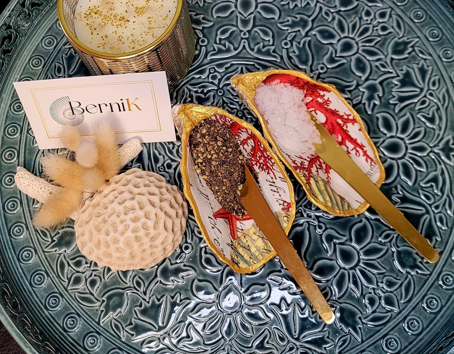 Salière et poivrière en coquille d'huître, avec un motif de corail rouge, parfaites pour une table élégante et écoresponsable.